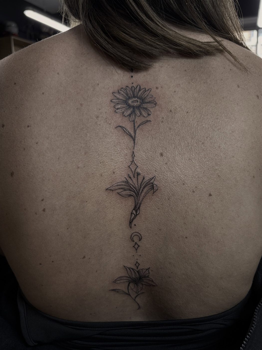 Fine line floral spine tattoo